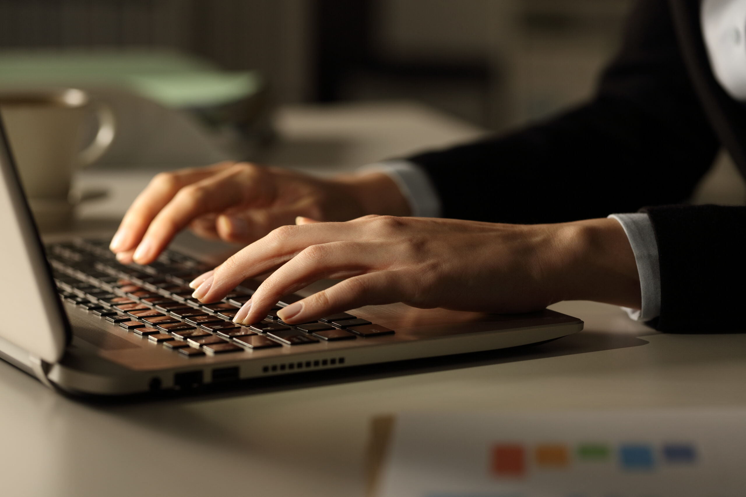Business woman hands typing on laptop at night